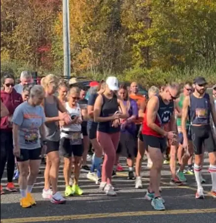 Runners gathered shoulder to shoulder at the start line of a road race