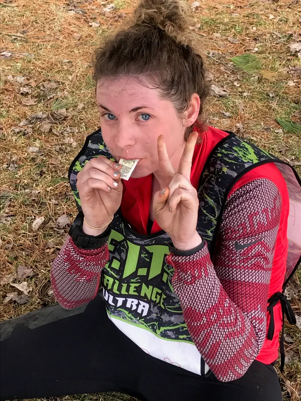 Kristina Petit taking on fuel in race kit and hydration vest during an autumn event